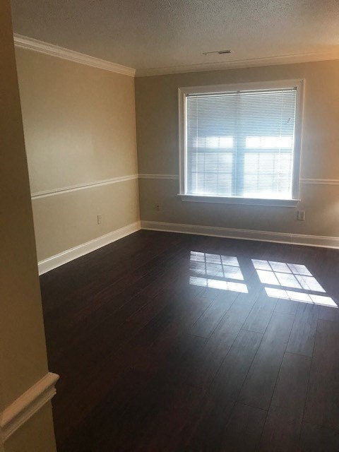 an empty room with a window and wooden floors