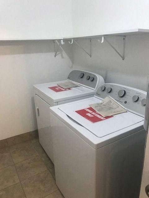 two white washing machines in a small room