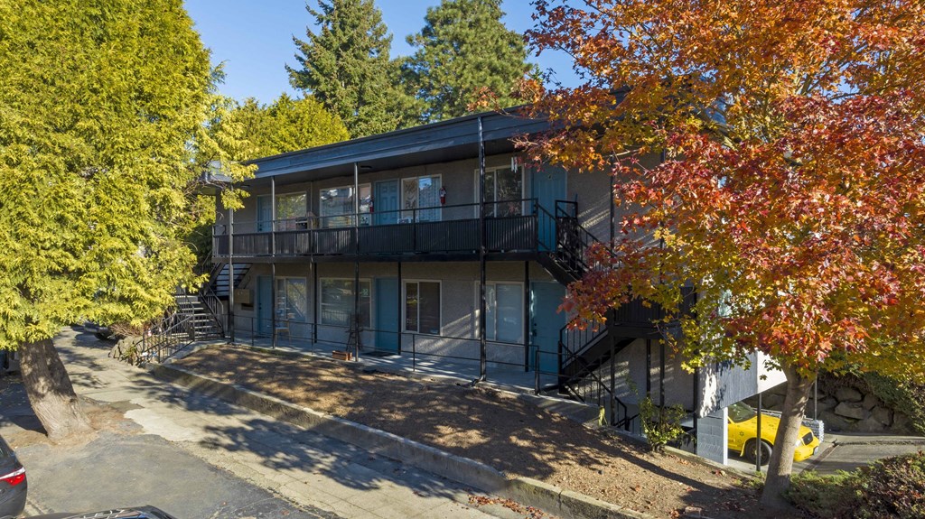 the exterior of a building with trees in front of it