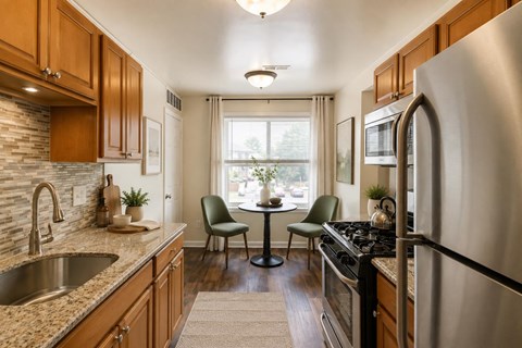 A kitchen with a stove, sink, and chairs.