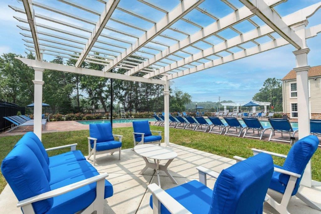 a patio with blue chairs and a white canopy
