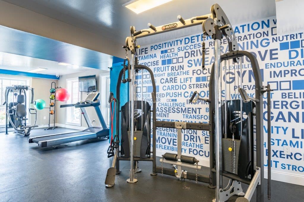 a gym with weights and a wall with words on it