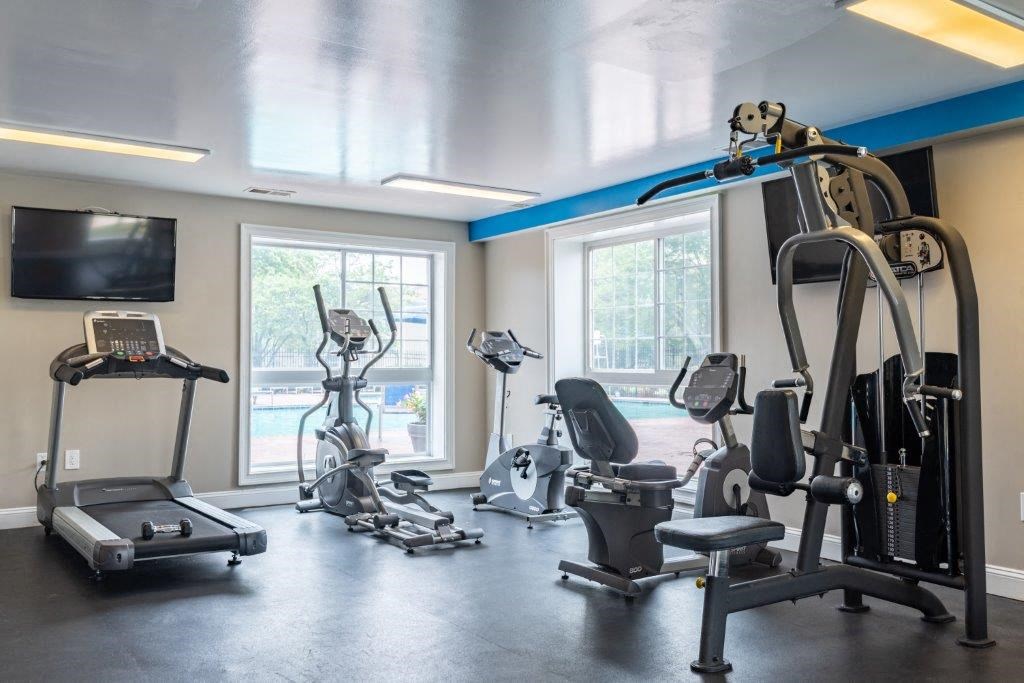 a gym with exercise equipment and a tv