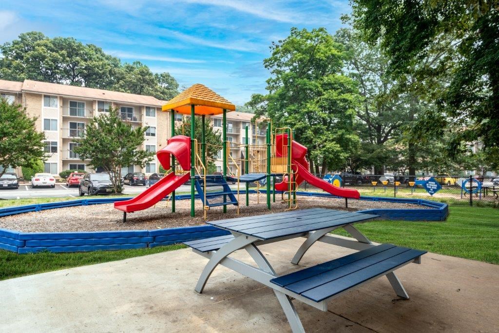 a playground with slides and a picnic table in a park