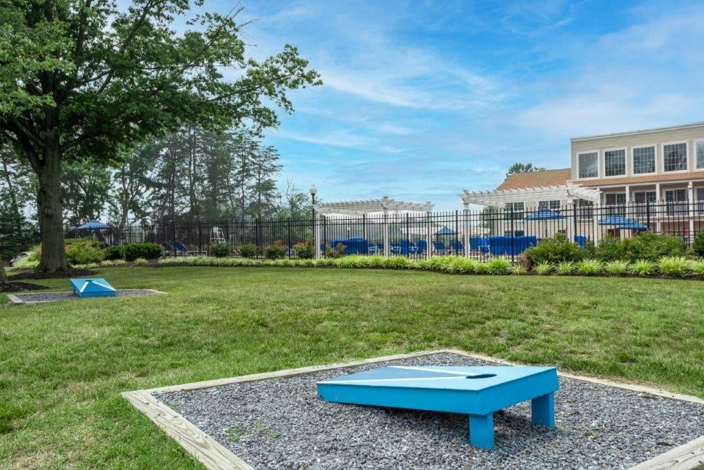 a blue ping pong table in the yard of a house with a pool