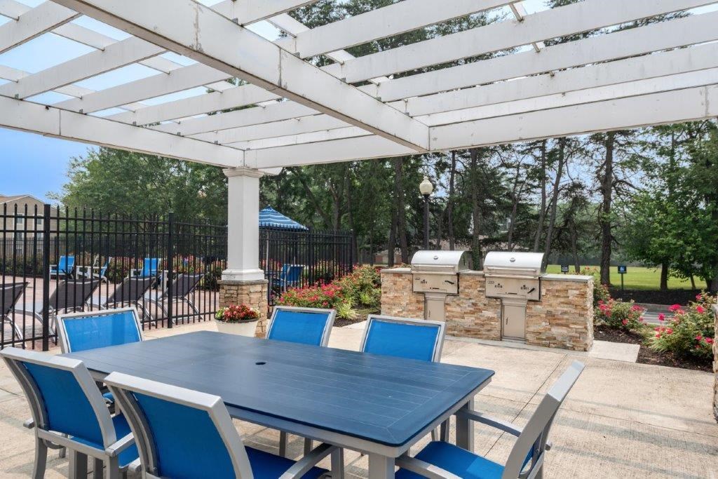 a dining table with blue chairs under a white patio