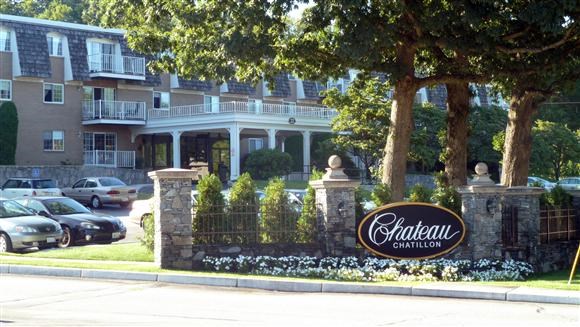 a sign on a fence in front of a house