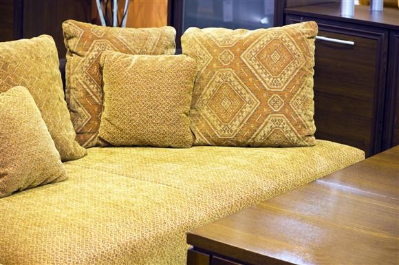 a couch with four pillows on it and a table