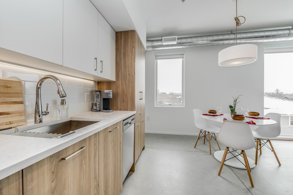 a kitchen with wooden cabinets and a sink and a table and chairs
