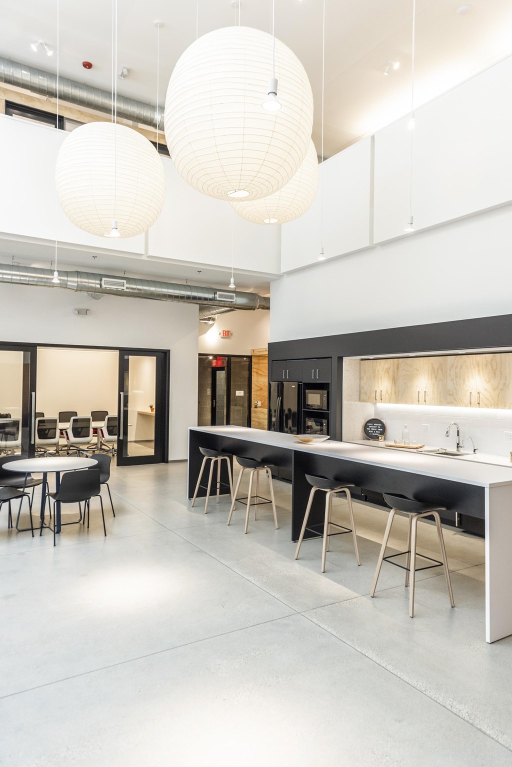 a large room with tables and chairs and a kitchen