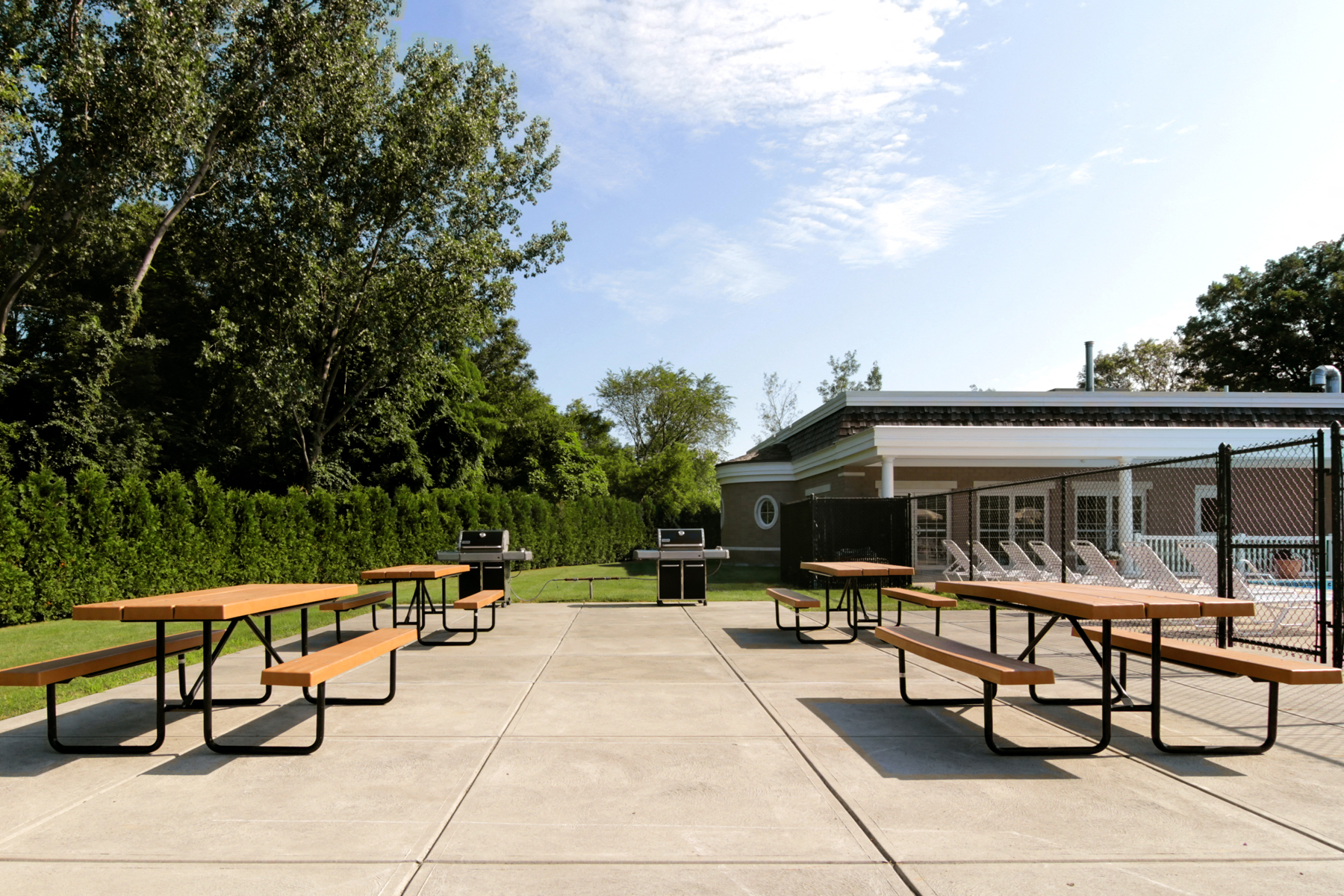 a picnic area with benches and tables and a building with a grill
