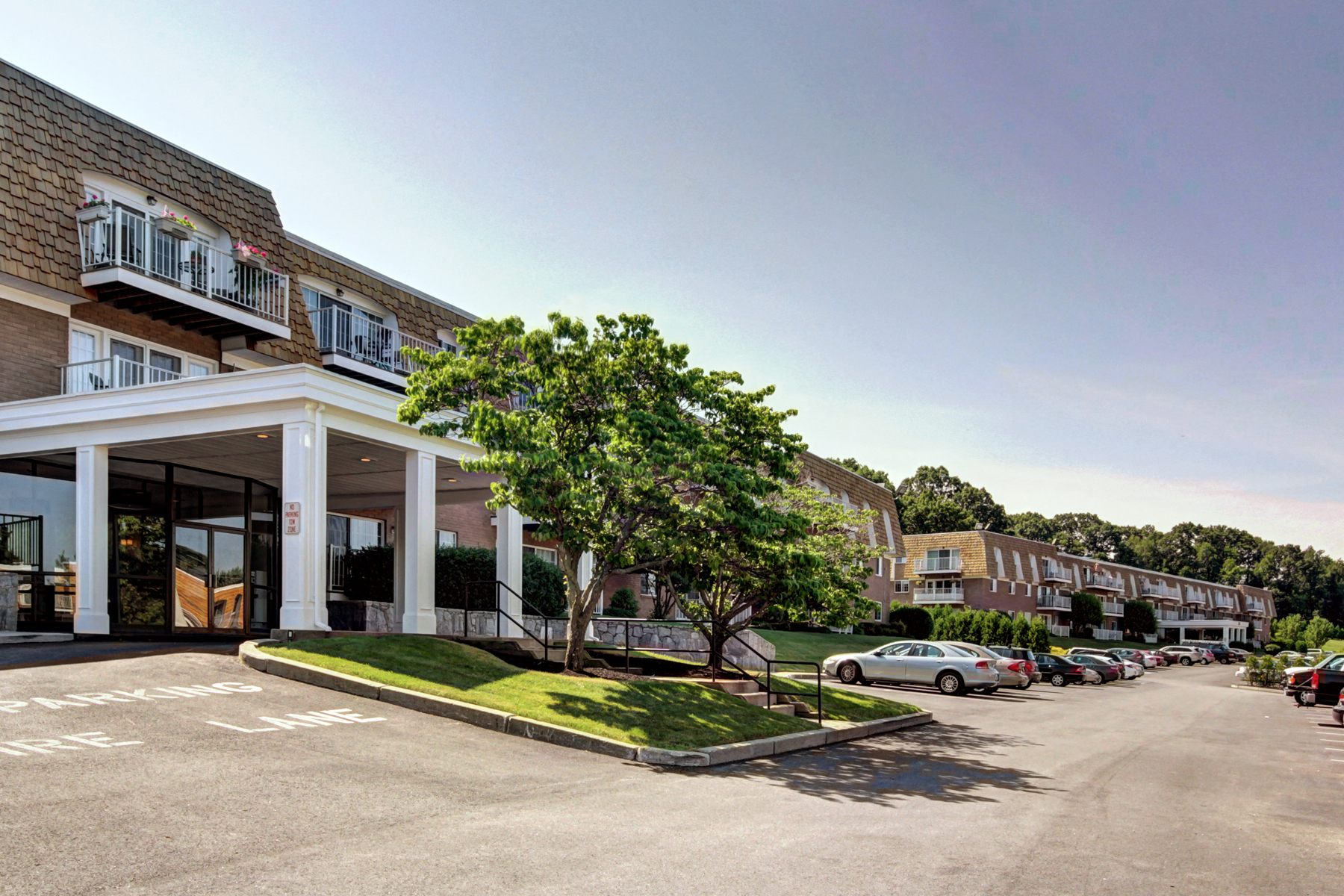 a parking lot in front of a building with cars parked