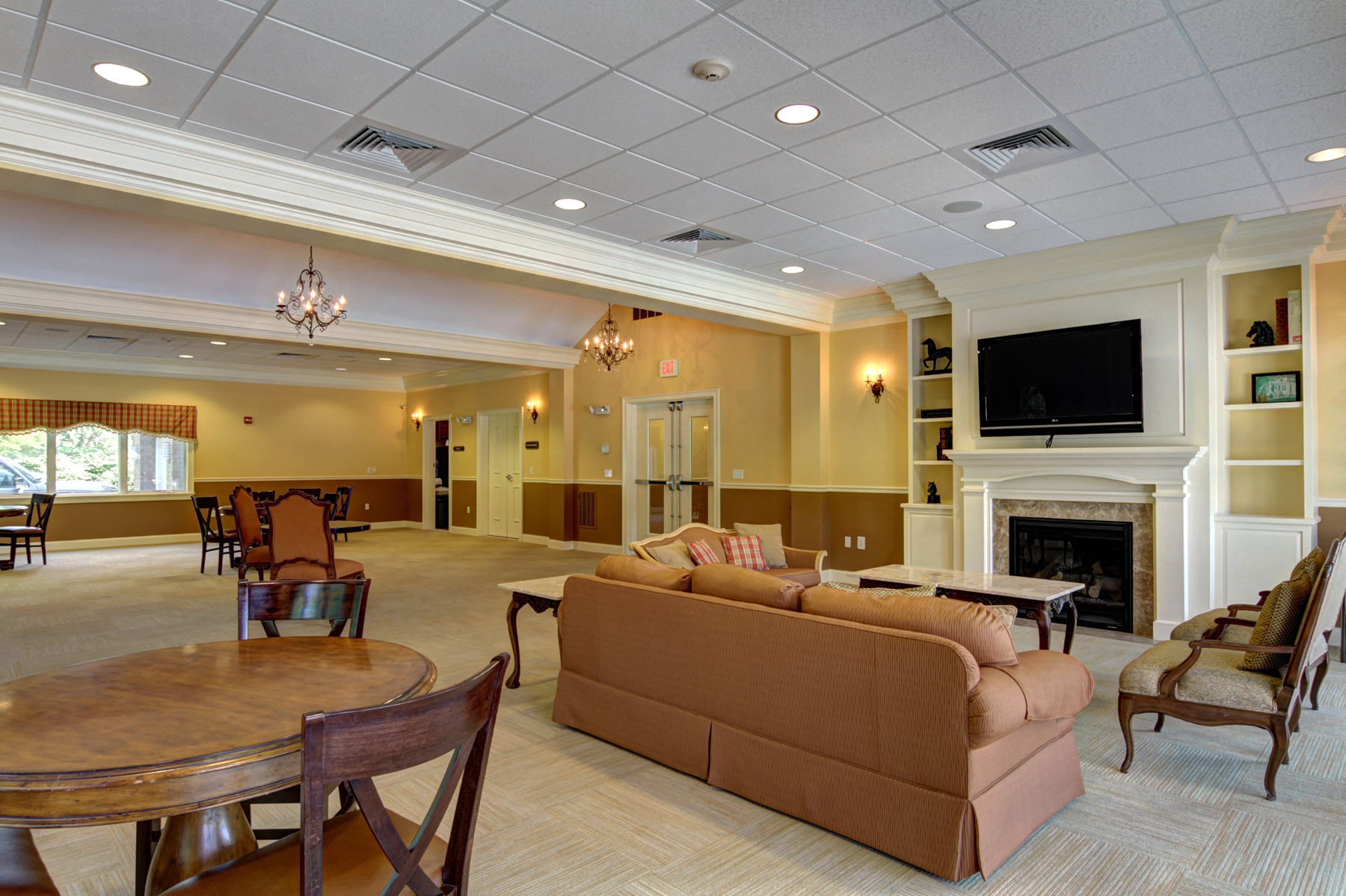a large living room with a fireplace and a table and chairs