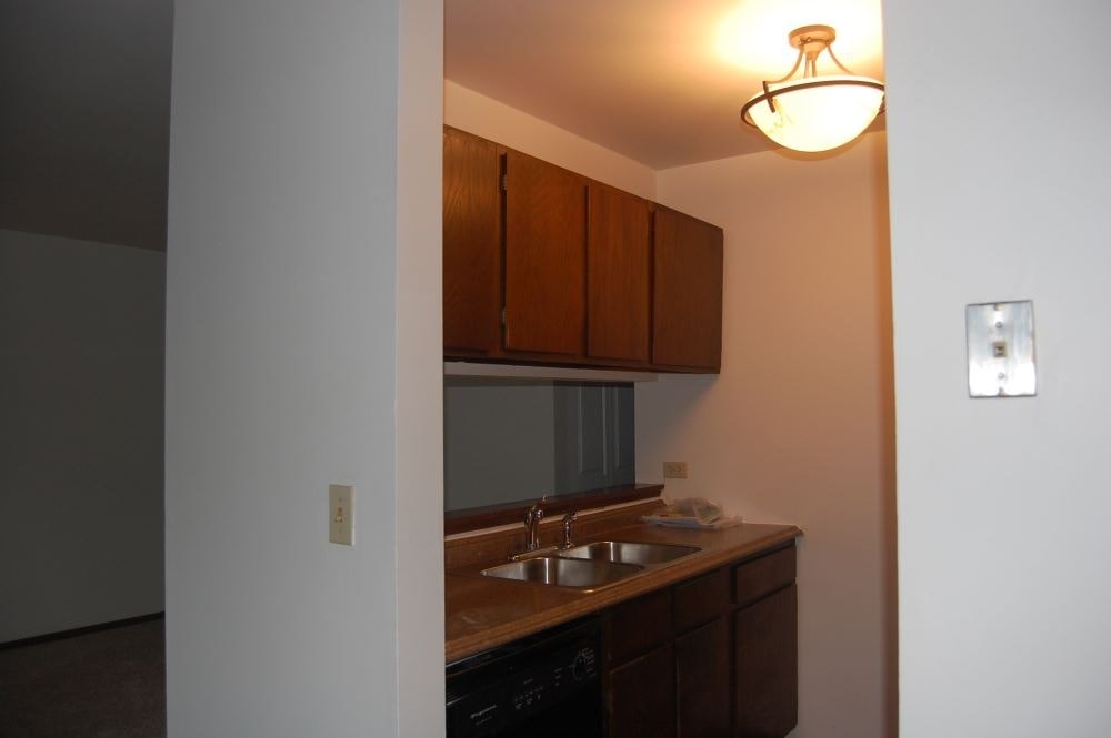 A kitchen with brown cabinets and a sink.