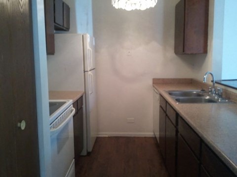 A kitchen with a white refrigerator and a white dishwasher.