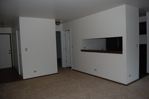 A white room with a brown carpet and a fireplace.