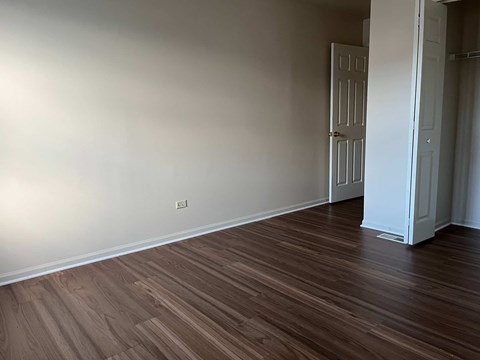 A room with wooden flooring and a white door.
