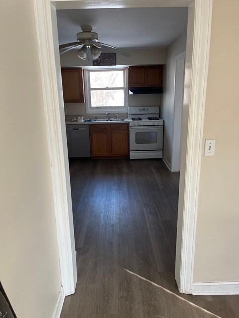 A kitchen with white appliances and wooden cabinets.