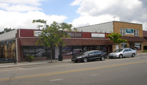 a city street with cars parked in front of a building