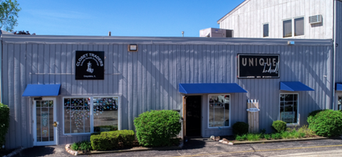 A building with a blue awning and a sign that says "UNIQUE".