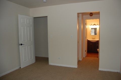 an empty living room with a door open to a bathroom