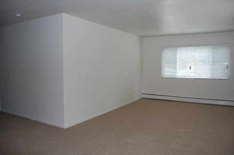 a bedroom with white walls and a window