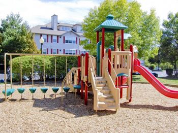 a playground with a slide and monkey bars  at Residences at Westborough Station, Massachusetts, 01581