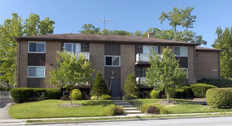 A brown building with a green lawn in front.
