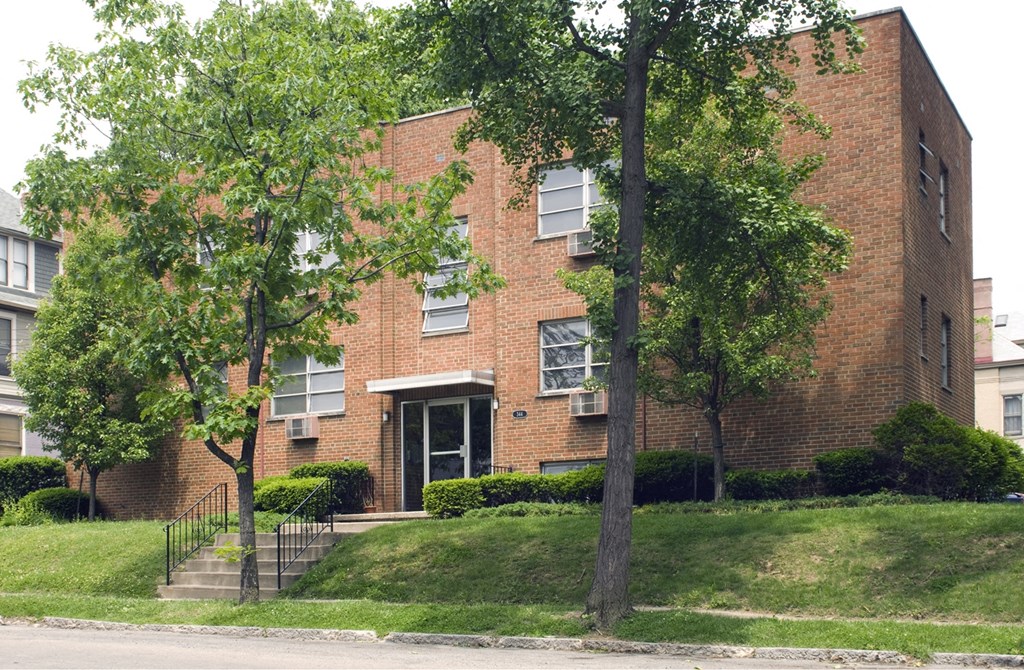 A red brick building with a black gate in front.