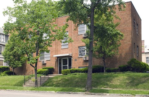 A red brick building with a black gate in front.