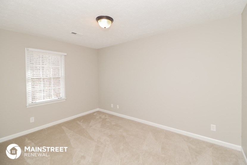 the living room of an empty home with a window