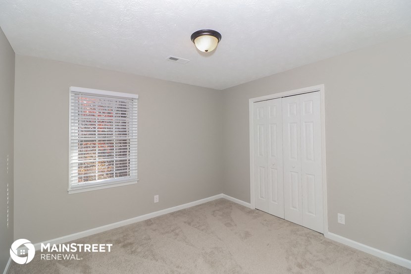 an empty room with a white door and a window and a ceiling light