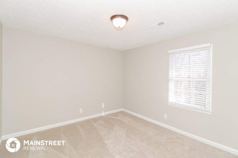 the living room of an empty bedroom with a window