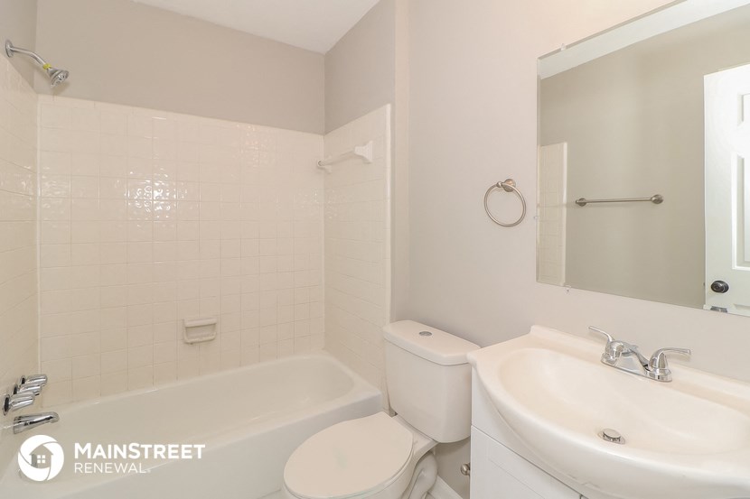 a white bathroom with a toilet and a sink
