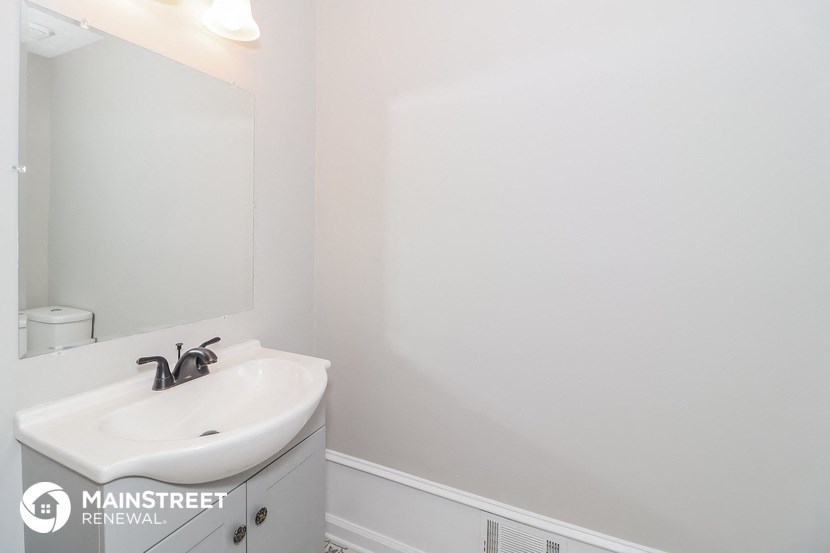 a white bathroom with a sink and a mirror