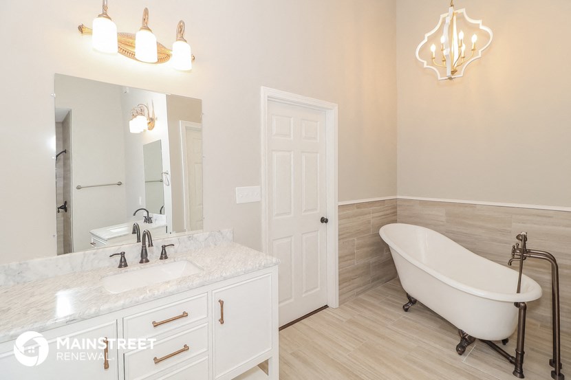a bathroom with a bath tub and a sink and a mirror