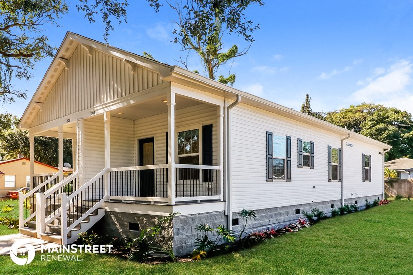 the front exterior of a white house with a porch