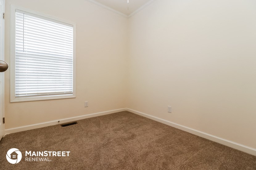 the upstairs bedroom with carpet and a window