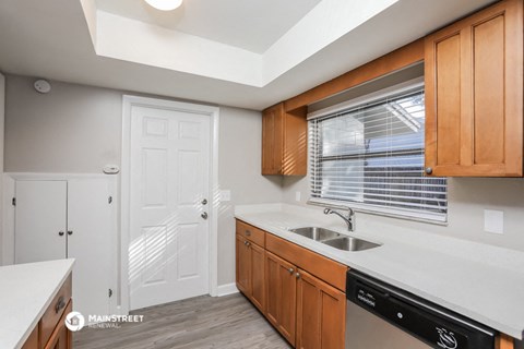 a kitchen with wooden cabinets and a sink and a window