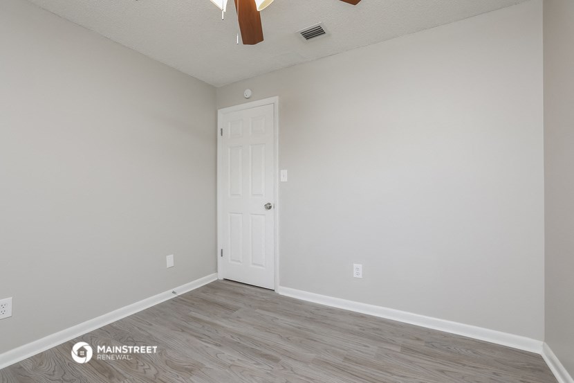 the spacious living room with a door to the bedroom