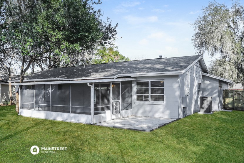 the exterior of a small gray house with a garage