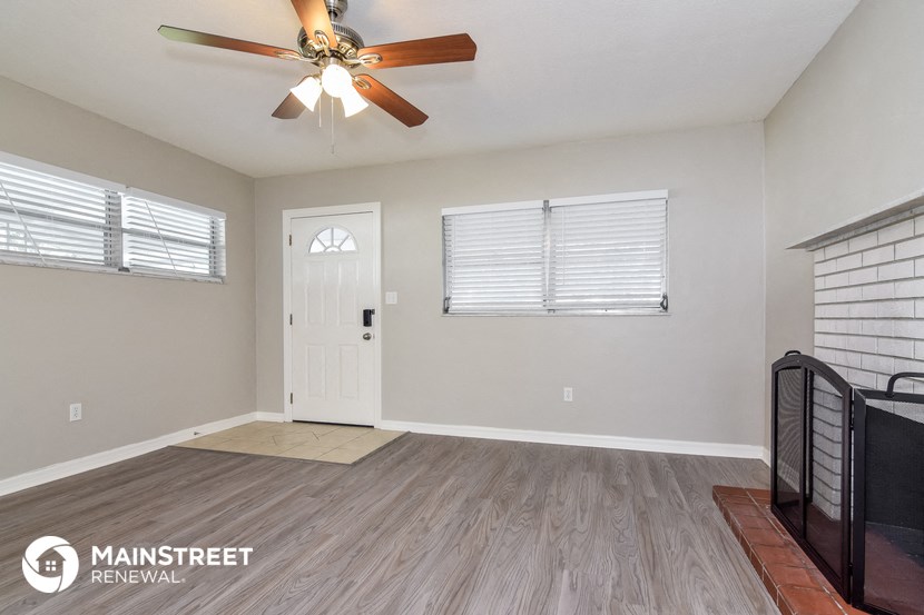 the living room is spacious and clean with a ceiling fan