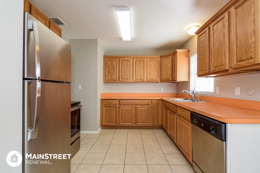 a kitchen with wooden cabinets and stainless steel appliances