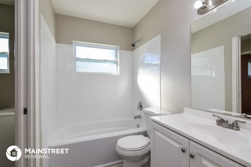 a white bathroom with a tub and a sink and a toilet