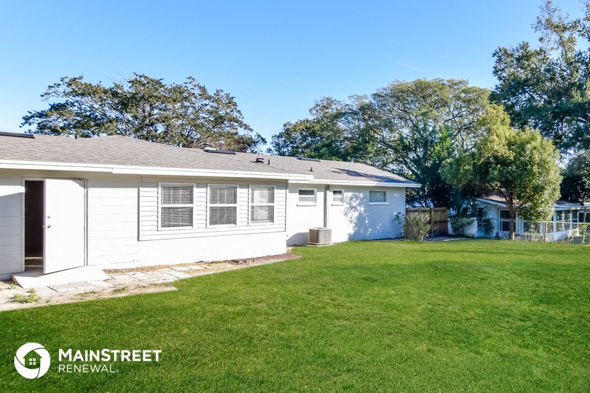 a small white house with a yard and a lawn