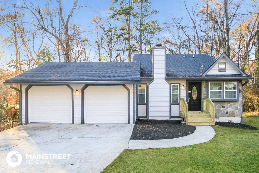 the front of a white house with a porch and a driveway