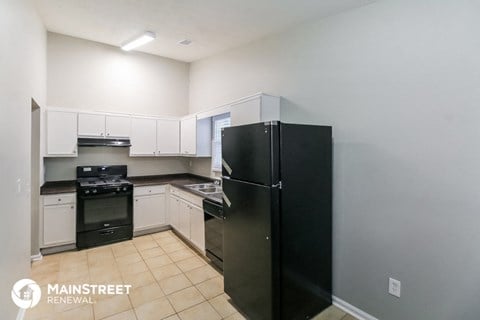 a kitchen with black appliances and white cabinets