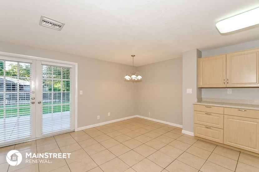 a kitchen and dining room with a door to the backyard