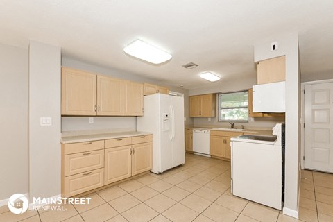a kitchen with white appliances and wooden cabinets