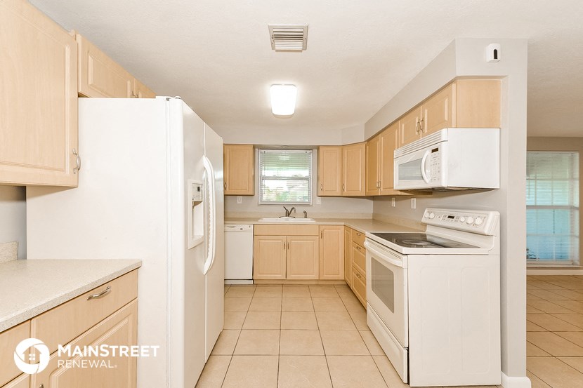 a kitchen with white appliances and wooden cabinets
